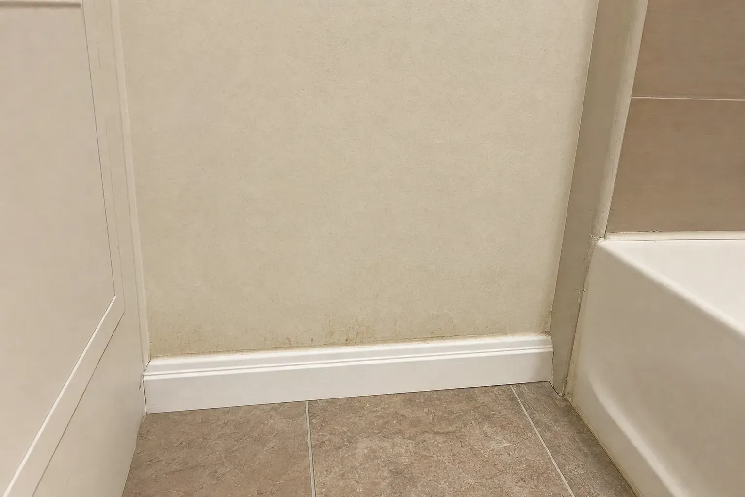 Lower bathroom wall near the tub where moisture readings were taken during the inspection.